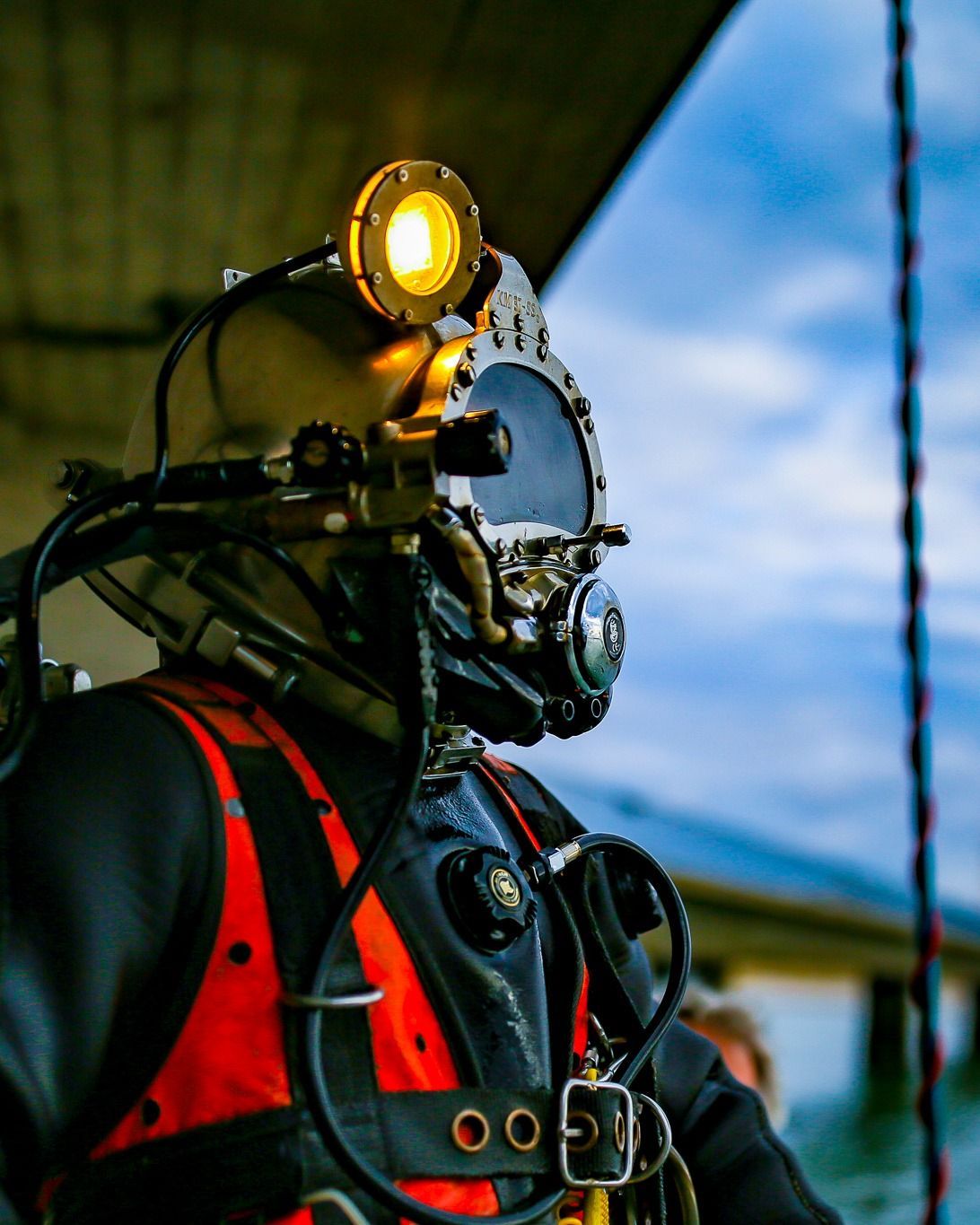 Berufstaucher mit Taucherhelm und Helmlampe, bereit zum Abstieg