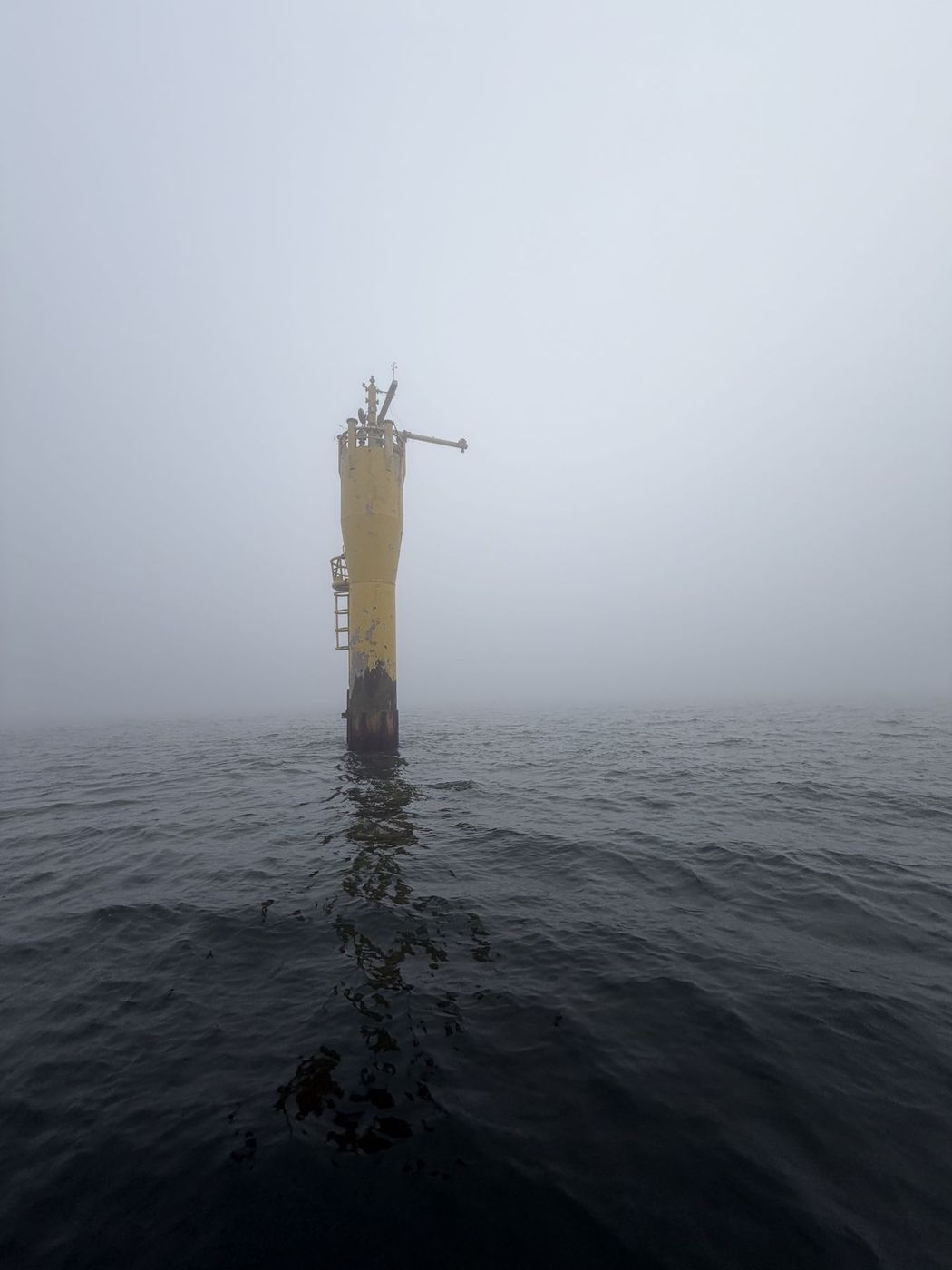 Pfahl im Meer bei dichtem Nebel